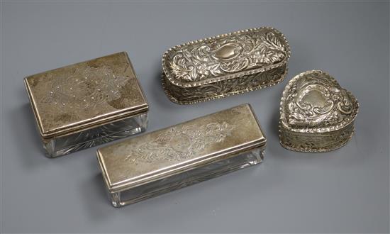 Two silver trinket boxes and two silver topped glass boxes.